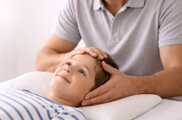Osteopathische Behandlung für Kinder: Kind liegt entspannt auf der Liege.